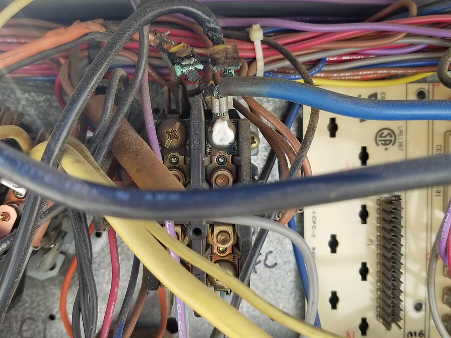 Burned AC contactor wiring inspected during burning smell diagnostics