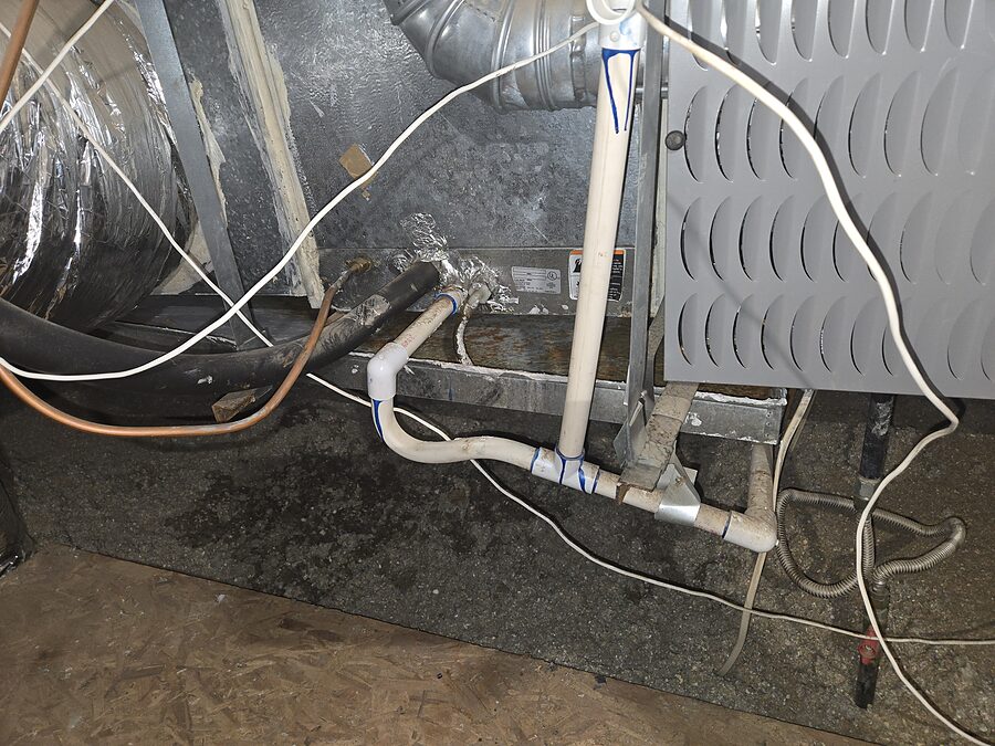 Indoor air handler drain piping and wiring checked during AC water leak service