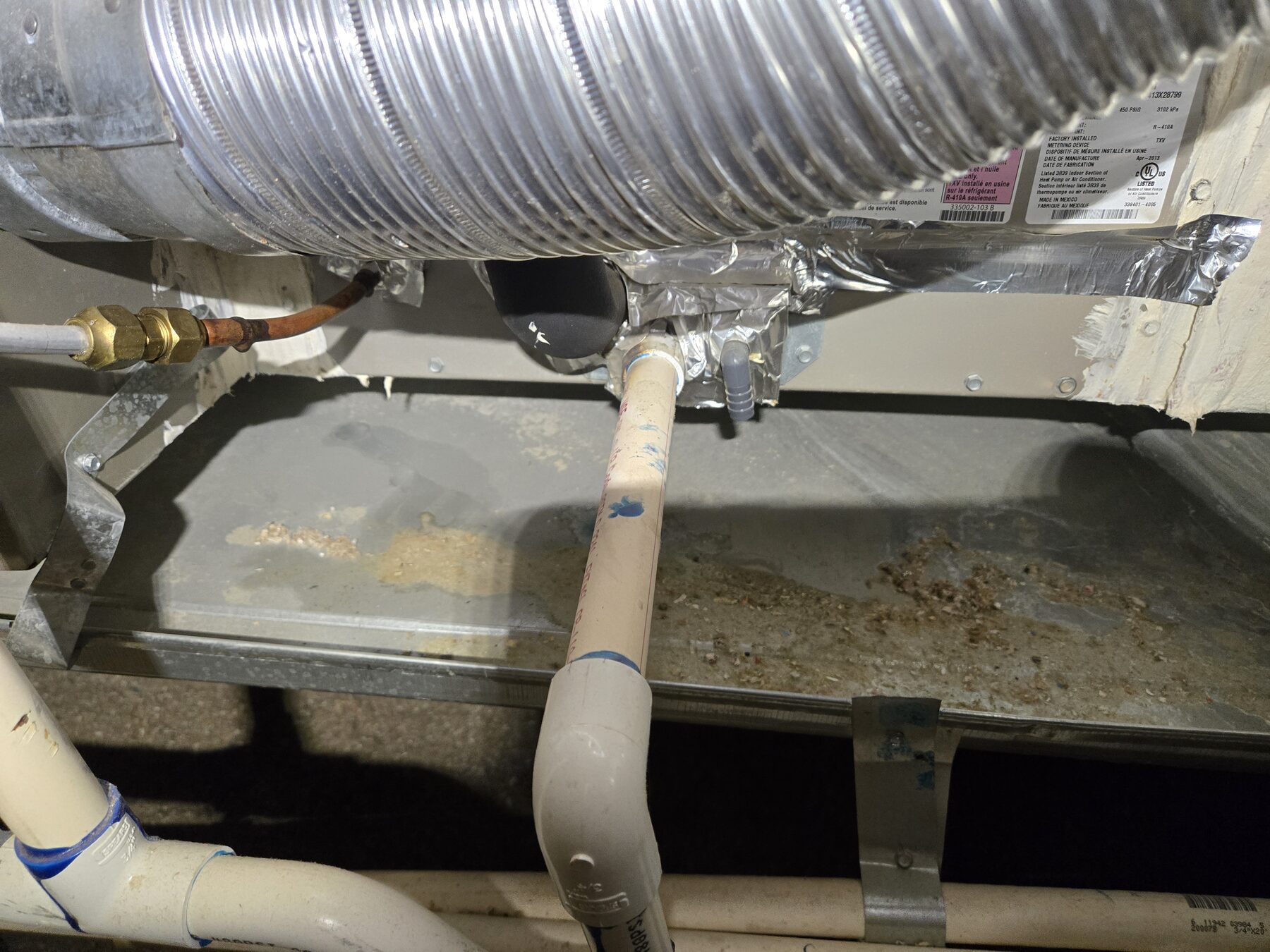 PVC condensate drain piping below HVAC equipment
