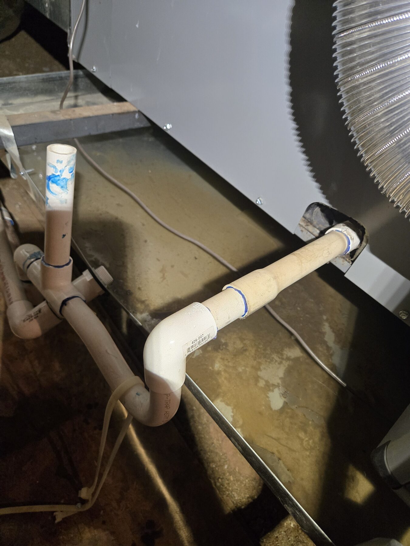 Close view of HVAC condensate line and drain connection