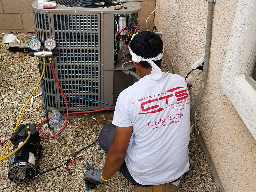 Technician diagnosing condenser fan motor and outdoor unit airflow in Phoenix