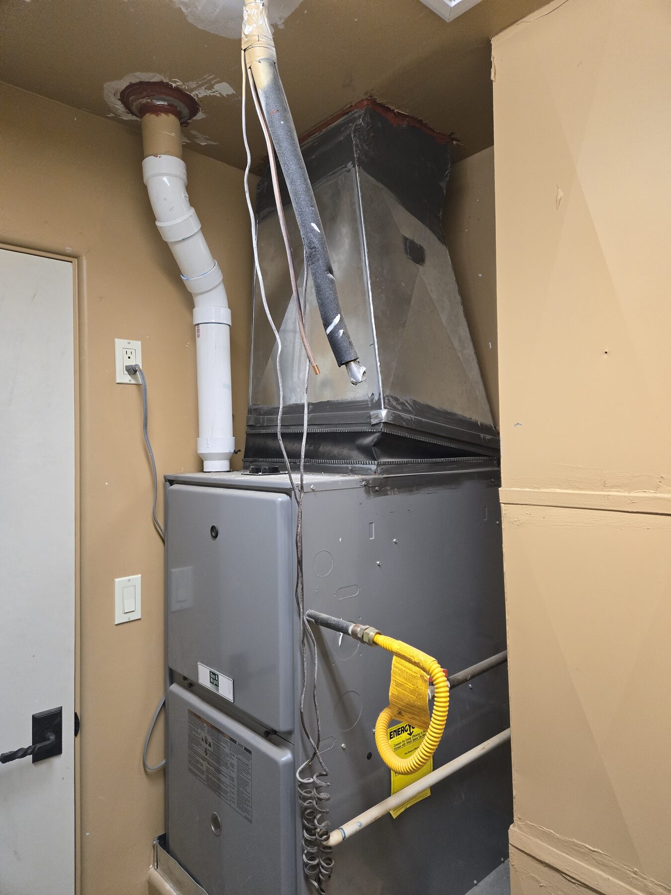 Open furnace closet where combustion air openings and access may be checked