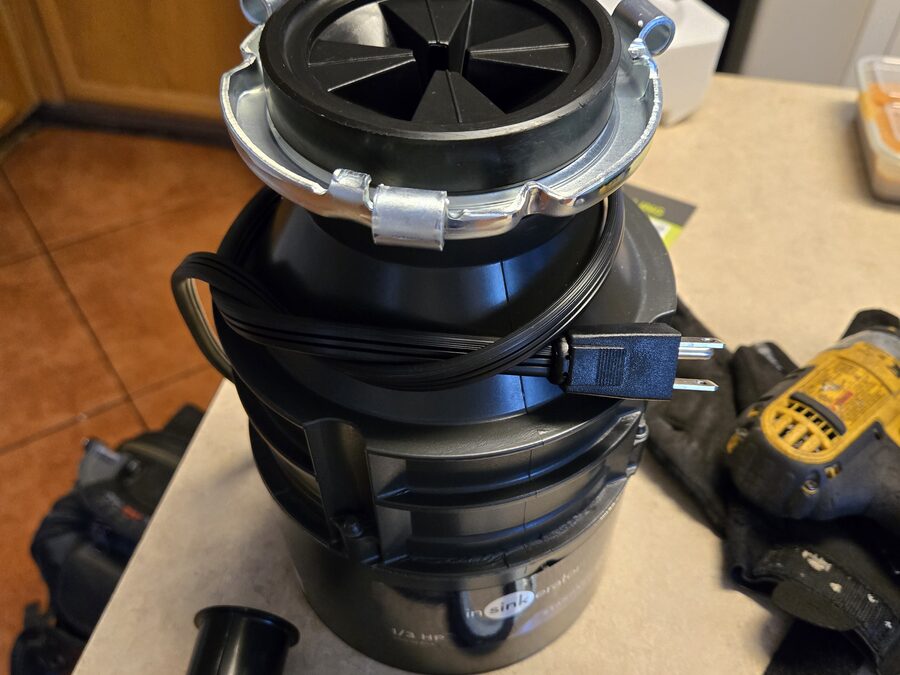 Garbage disposal replacement parts staged for disposal repair