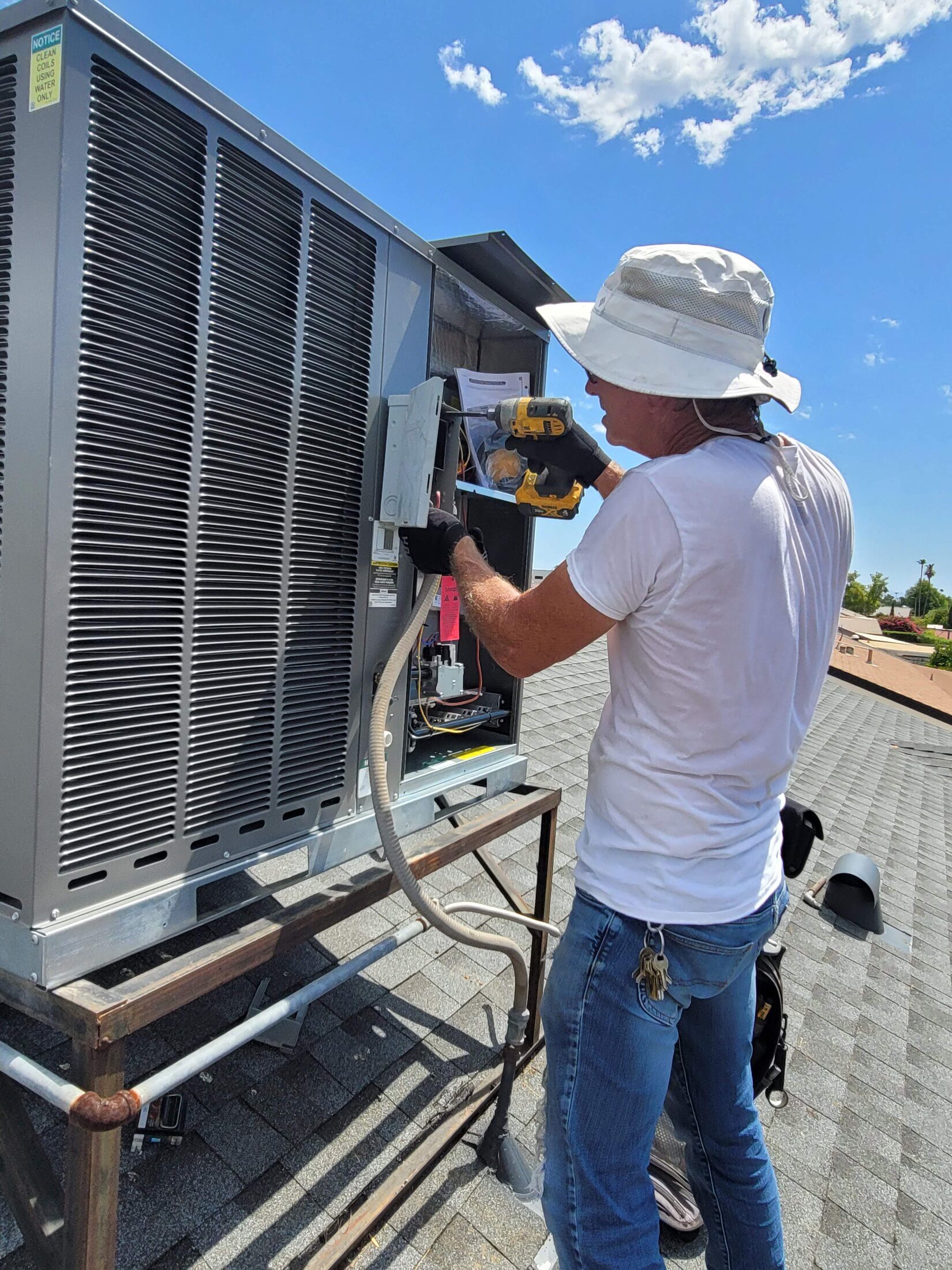 Technician servicing rooftop HVAC equipment in the Phoenix area