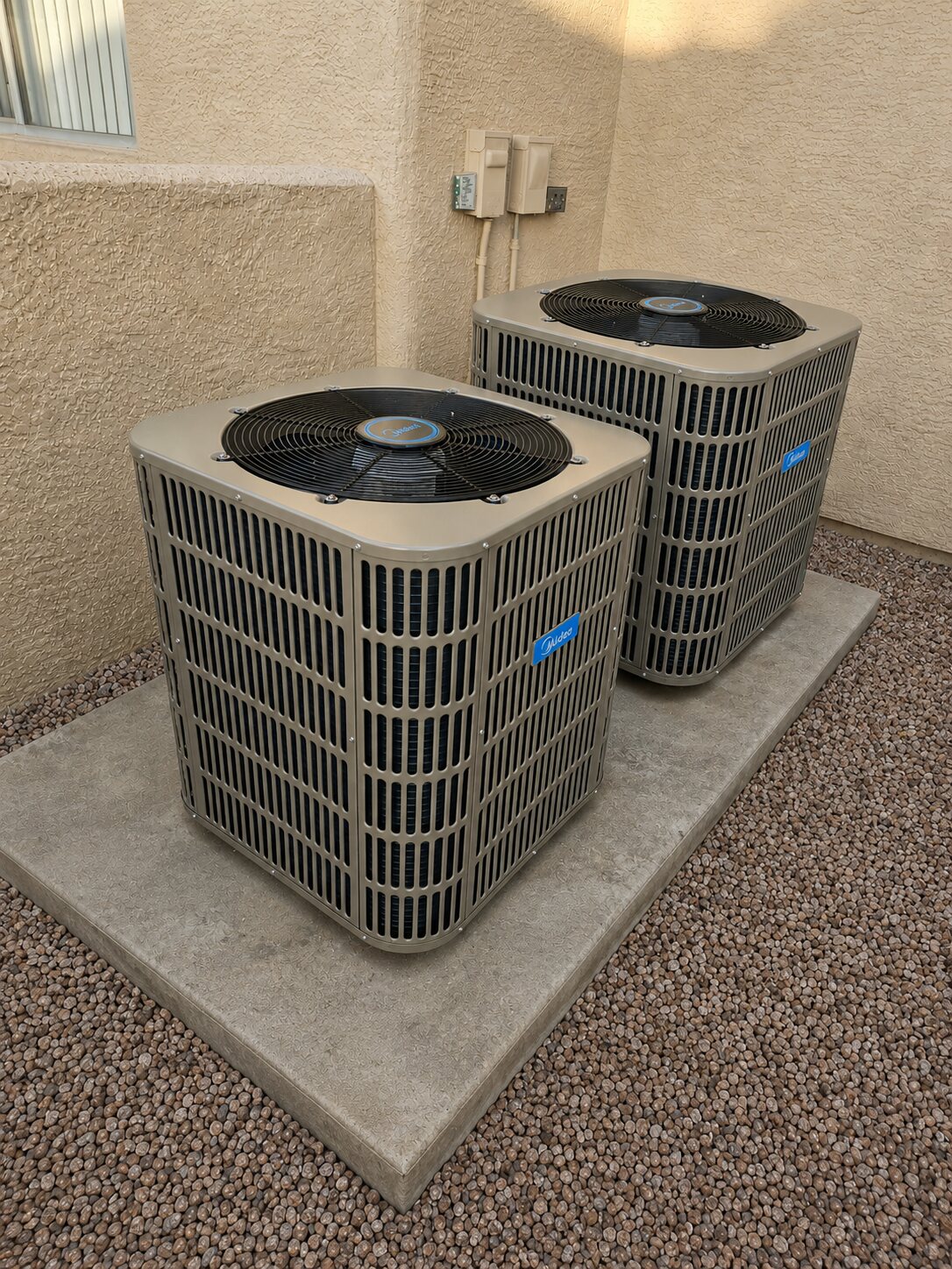 Two Midea outdoor AC condenser units installed beside a Phoenix area home
