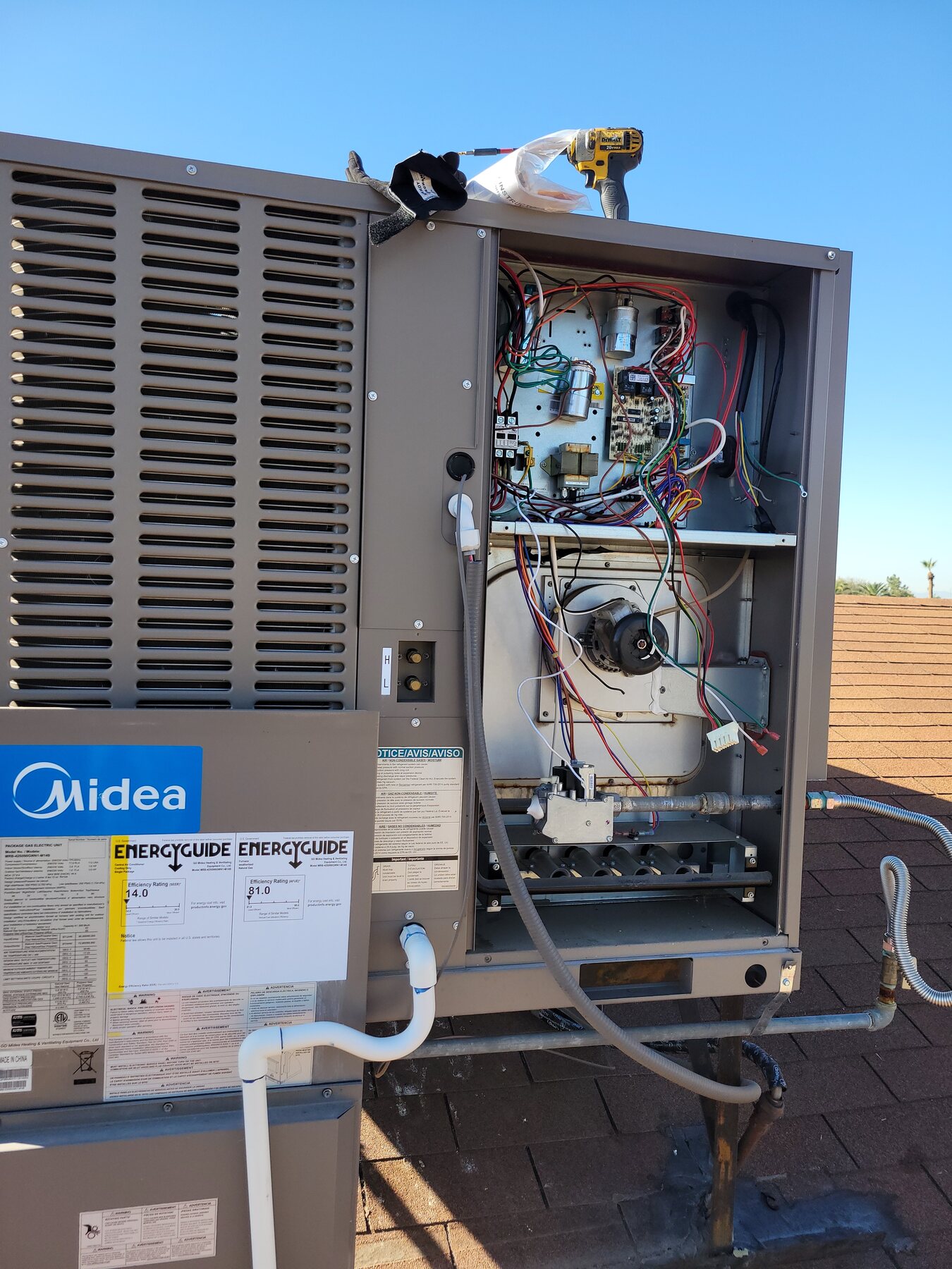 Open HVAC cabinet with wiring and diagnostic gauges connected