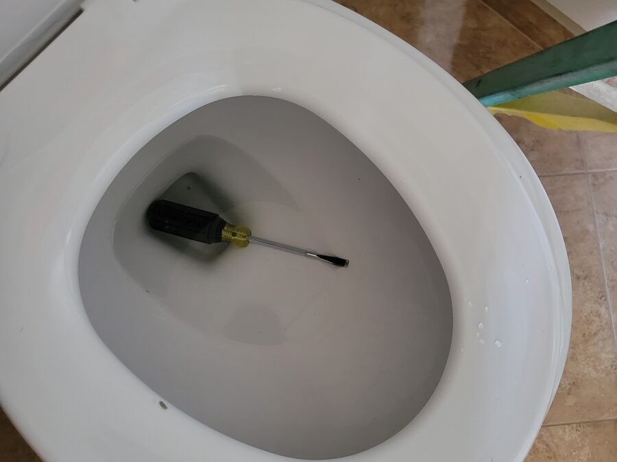 Toilet bowl and fixture area checked during toilet repair