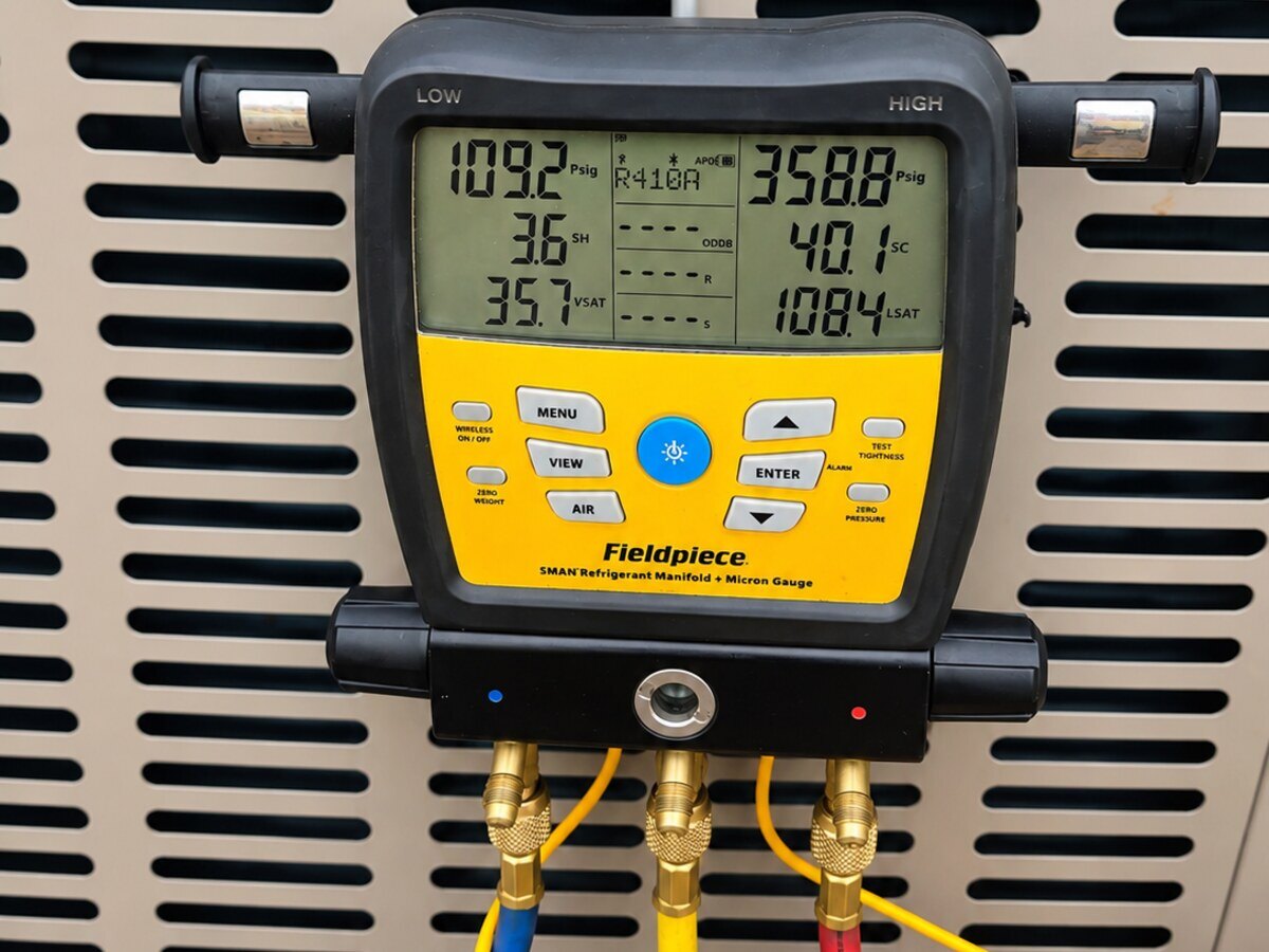 Digital refrigerant gauges connected during air conditioning diagnostics